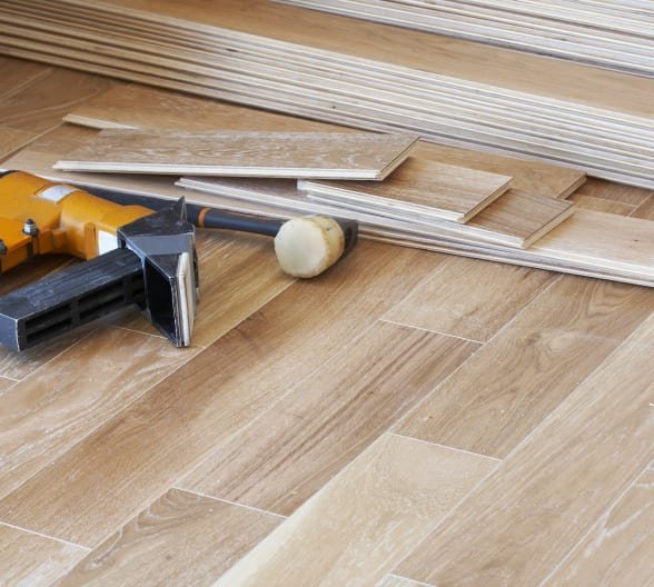 Tools and wooden flooring planks ready to be installed