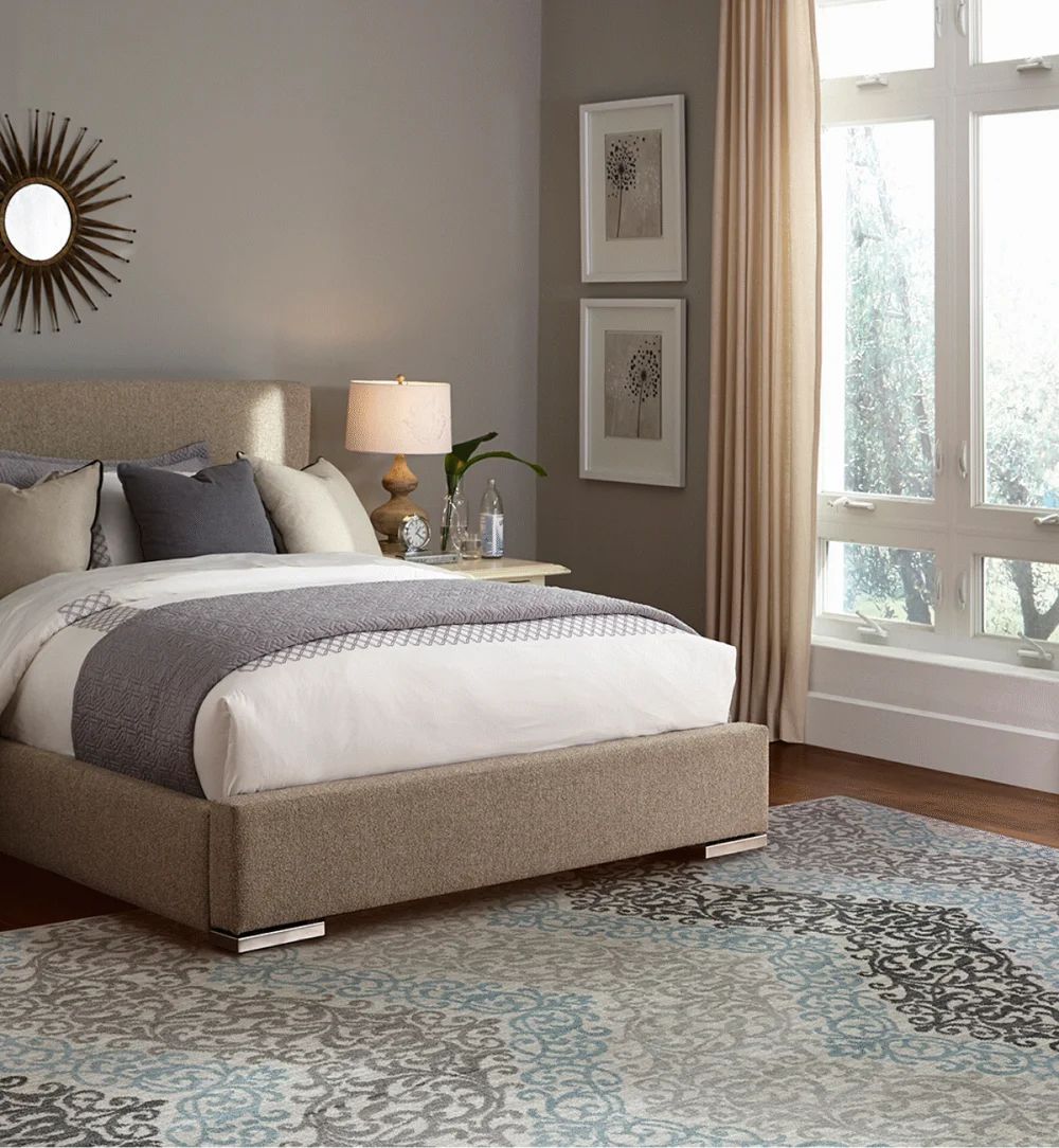 Patterned area rug in a taupe bedroom