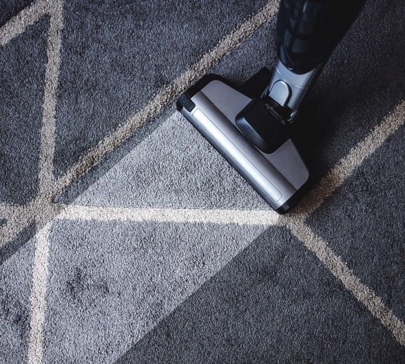 A vacuum machine cleaning a dirty navy carpet